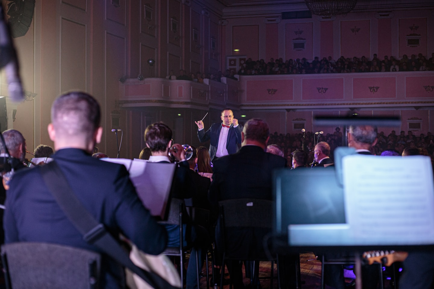 Un direttore d'orchestra guida un'orchestra durante un concerto in un teatro.
